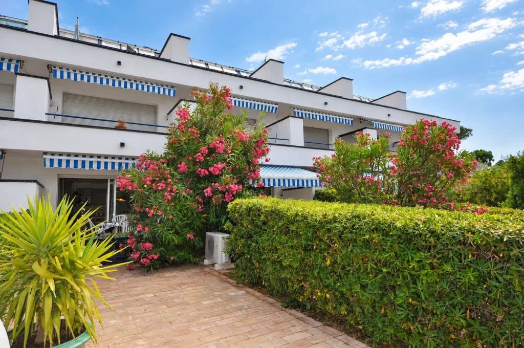 Residenz S'Alguer II und Terrasse umgeben von Rosenlagersträuchern — Ferienwohnung Dalí, La Fosca Bay (Palamós, Costa Brava)
