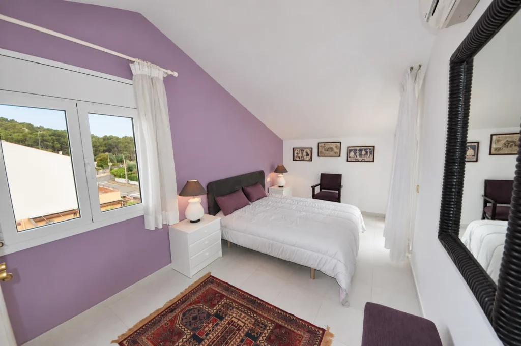 Lila Schlafzimmer mit Doppelbett unter dem Dach — Ferienwohnung Miró, La Fosca Bay (Palamós, Costa Brava)