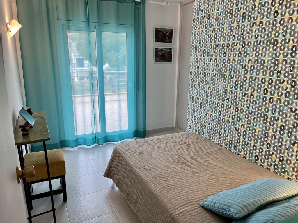 Türkisfarbenes Schlafzimmer mit Glastür zur Terrasse — Ferienwohnung Miró, La Fosca Bay (Palamós, Costa Brava)