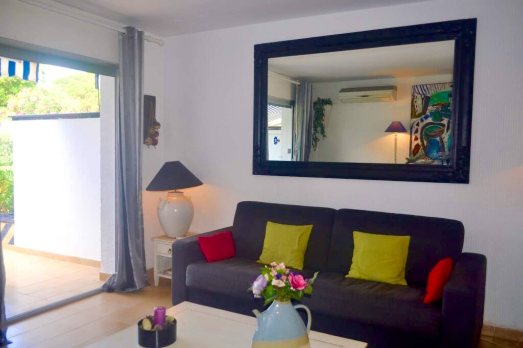 Wohnzimmer mit Sofa und großem Spiegel — Ferienwohnung Dalí, La Fosca Bay (Palamós, Costa Brava)