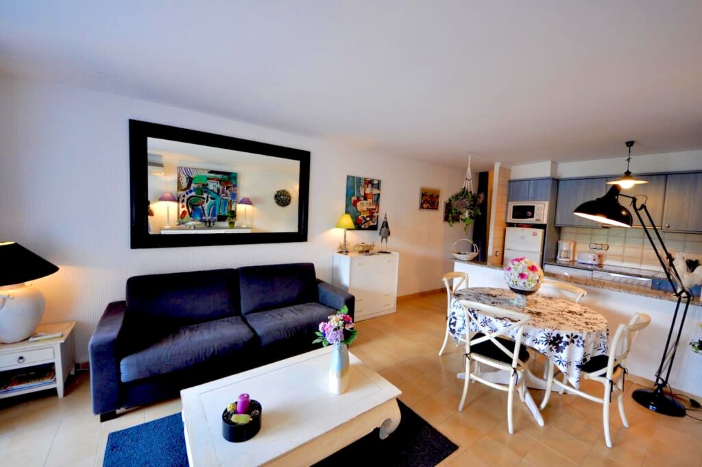 Wohnbereich mit Sofa, Esstisch und offener Küche — Ferienwohnung Dalí, La Fosca Bay (Palamós, Costa Brava)