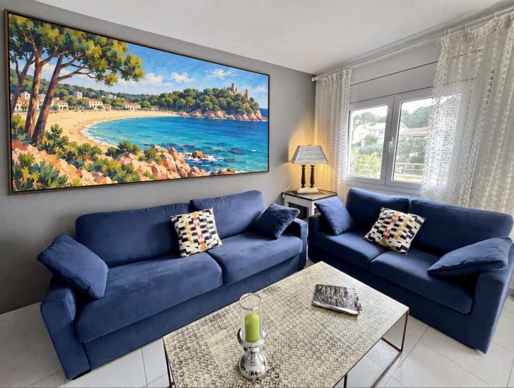Wohnzimmer mit blauen Sofas und Bild der Bucht von La Fosca — Ferienwohnung Miró, La Fosca Bay (Palamós, Costa Brava)